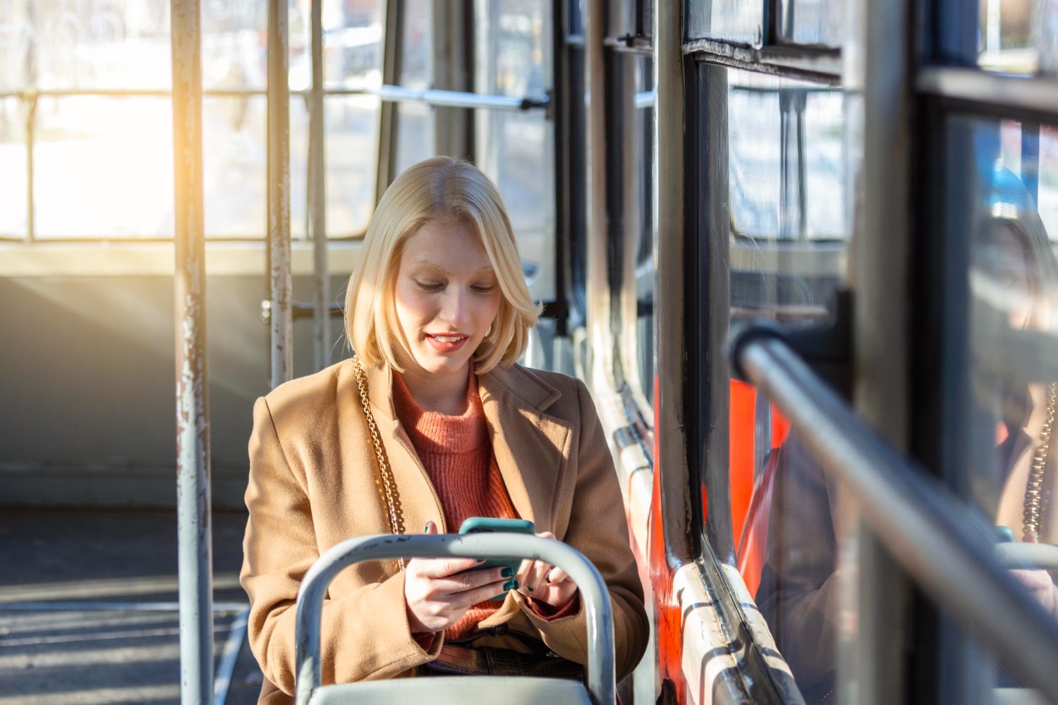 Woman On Bus Looking At Phone Smiling